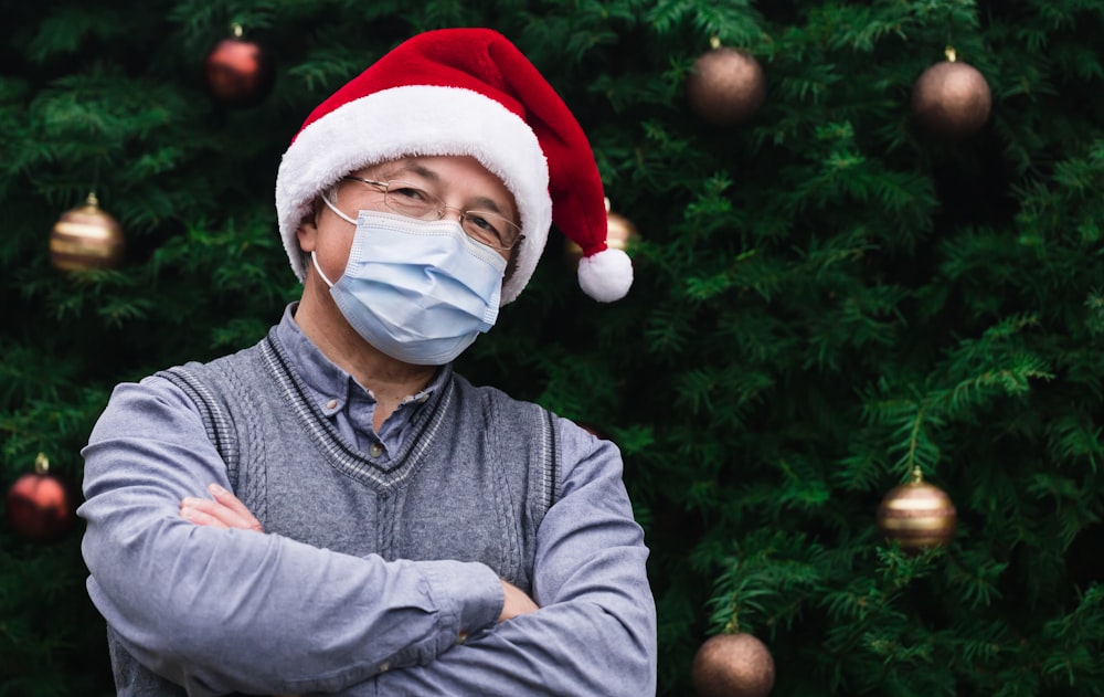 Hombre en suéter gris con sombrero de Papá Noel