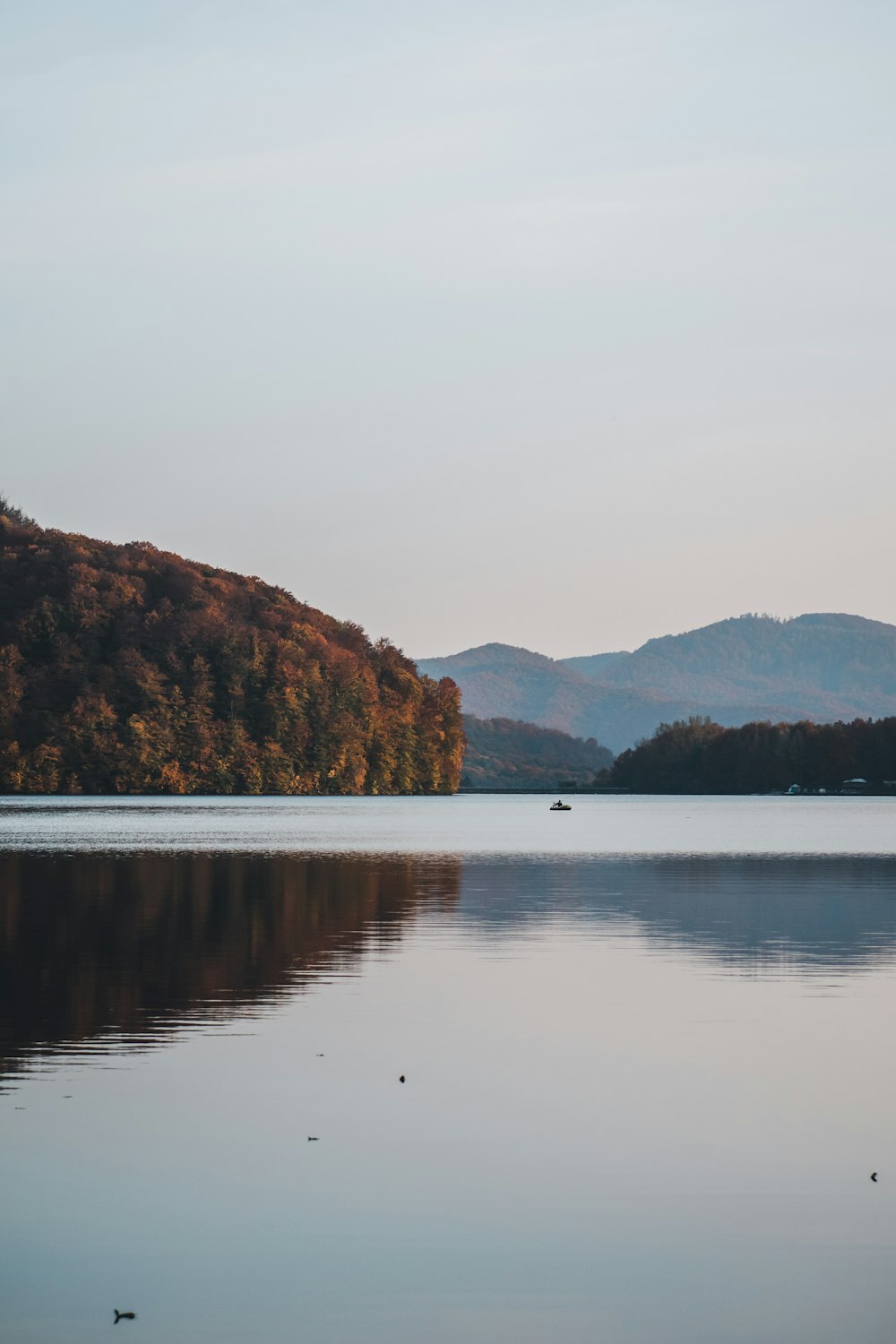 body of water near mountain during daytime