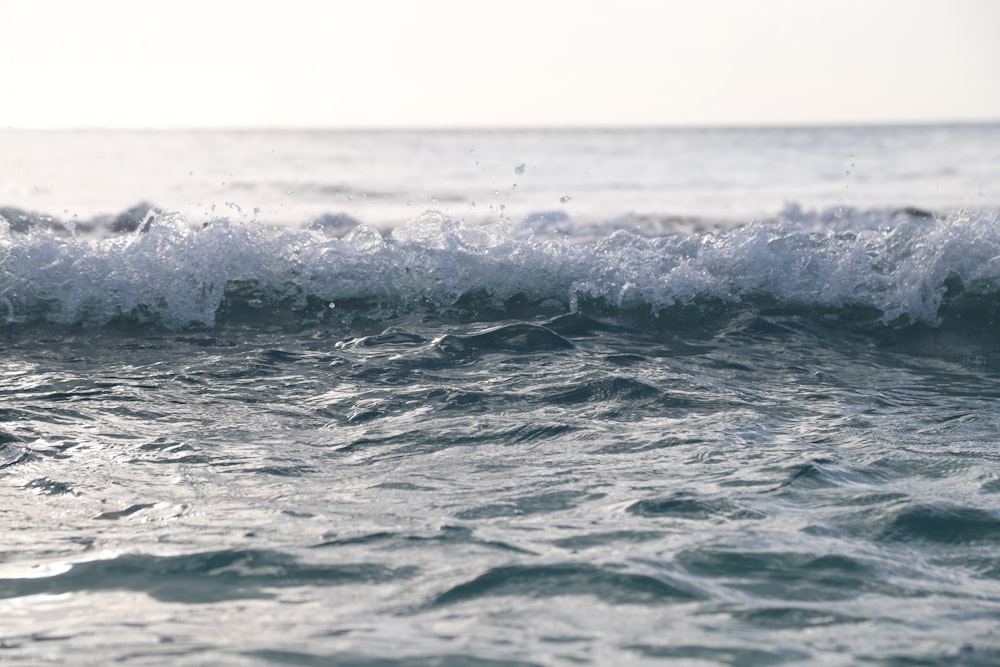 ocean waves under white sky during daytime