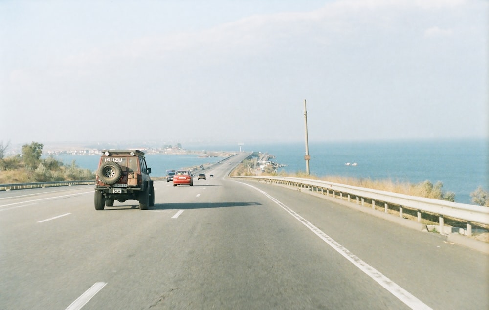 black suv on road near sea during daytime