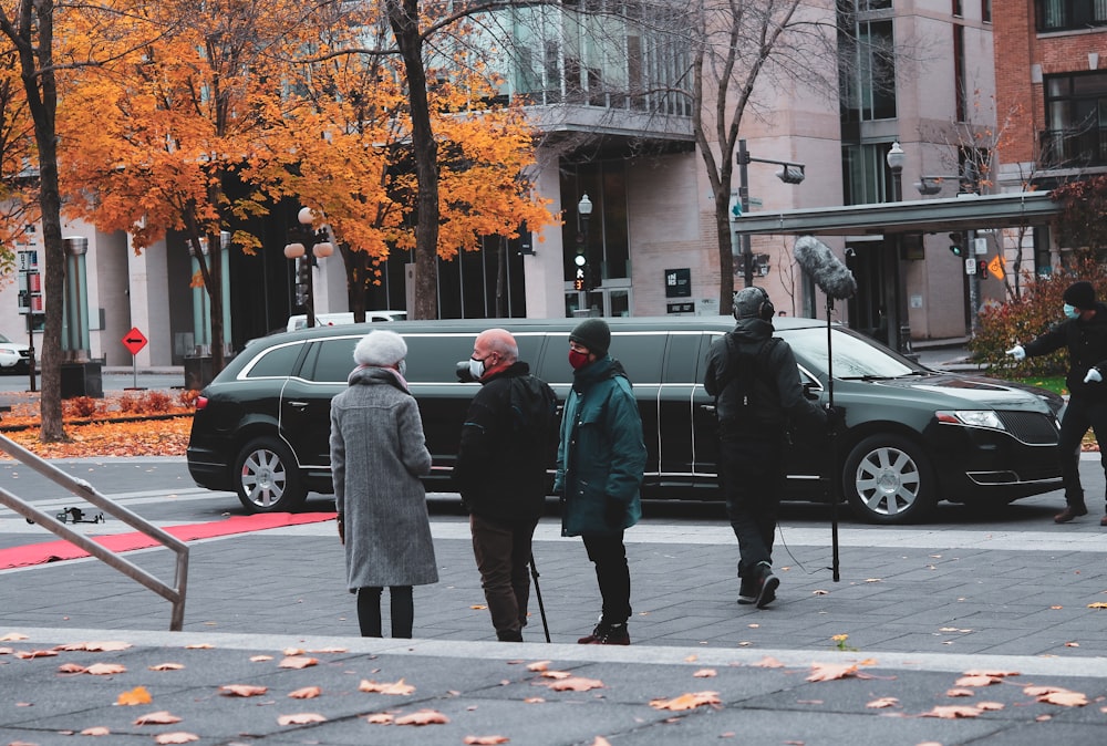 man in green coat walking on pedestrian lane during daytime