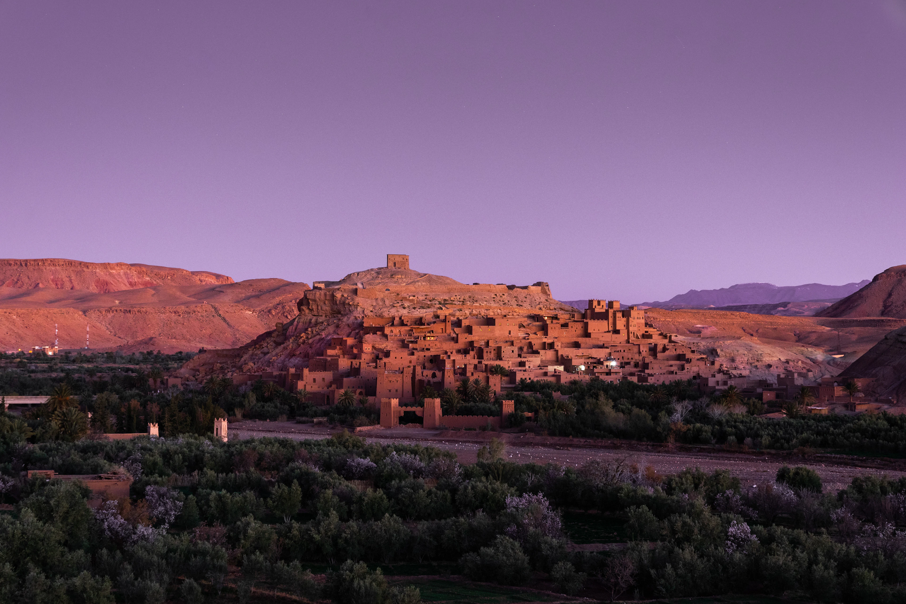 The earthen fortified village of Aït Benhaddou among palms and brown hills