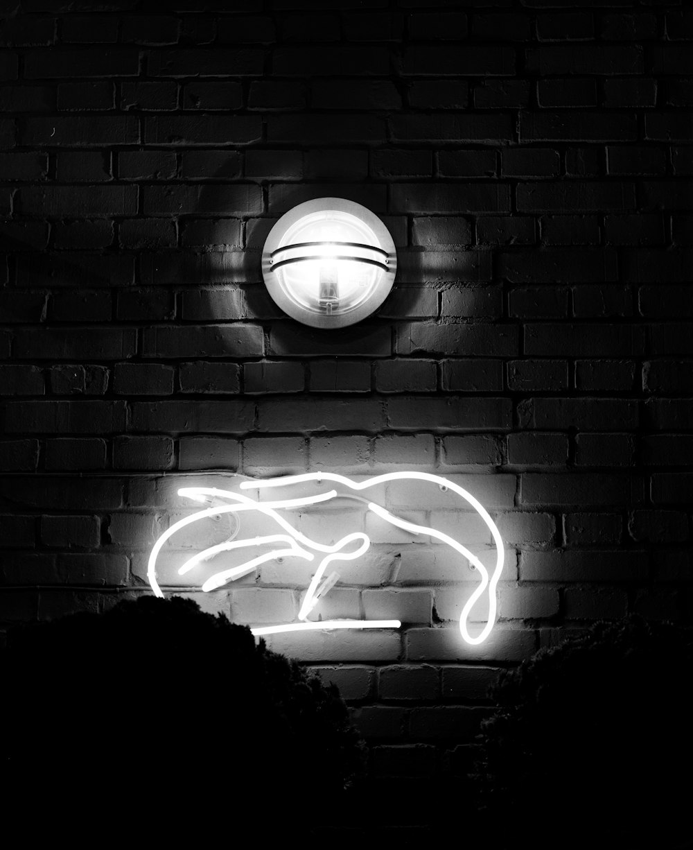 white light bulb on black brick wall