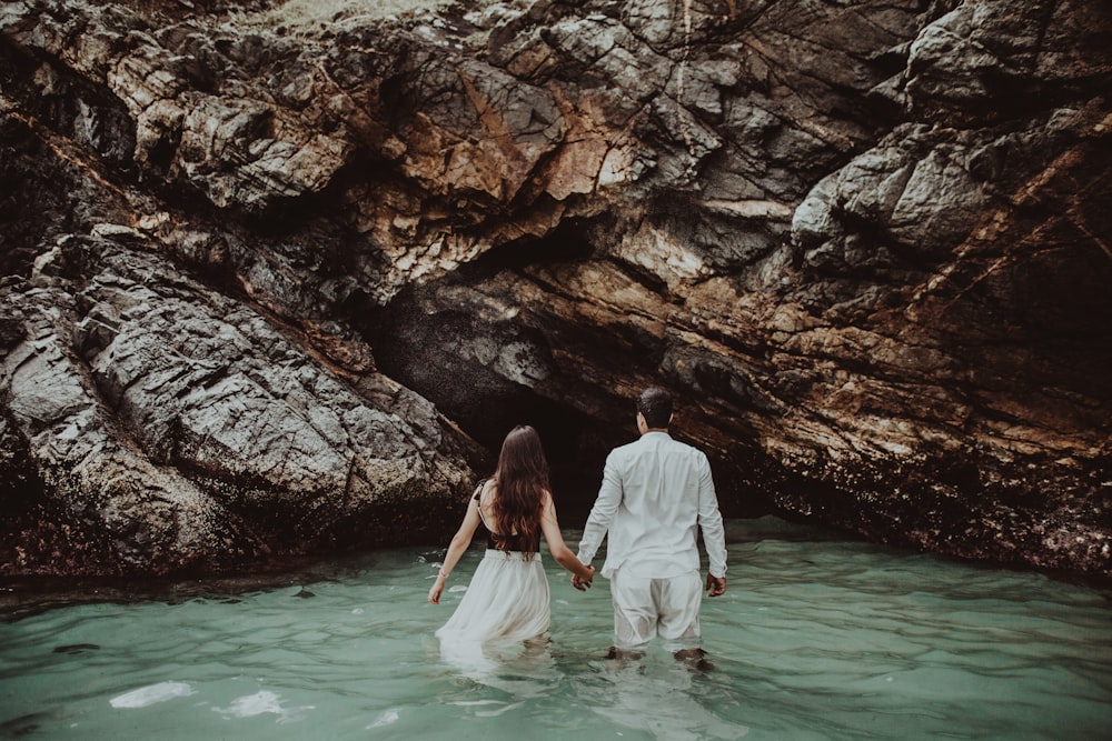 a man and a woman are walking in the water