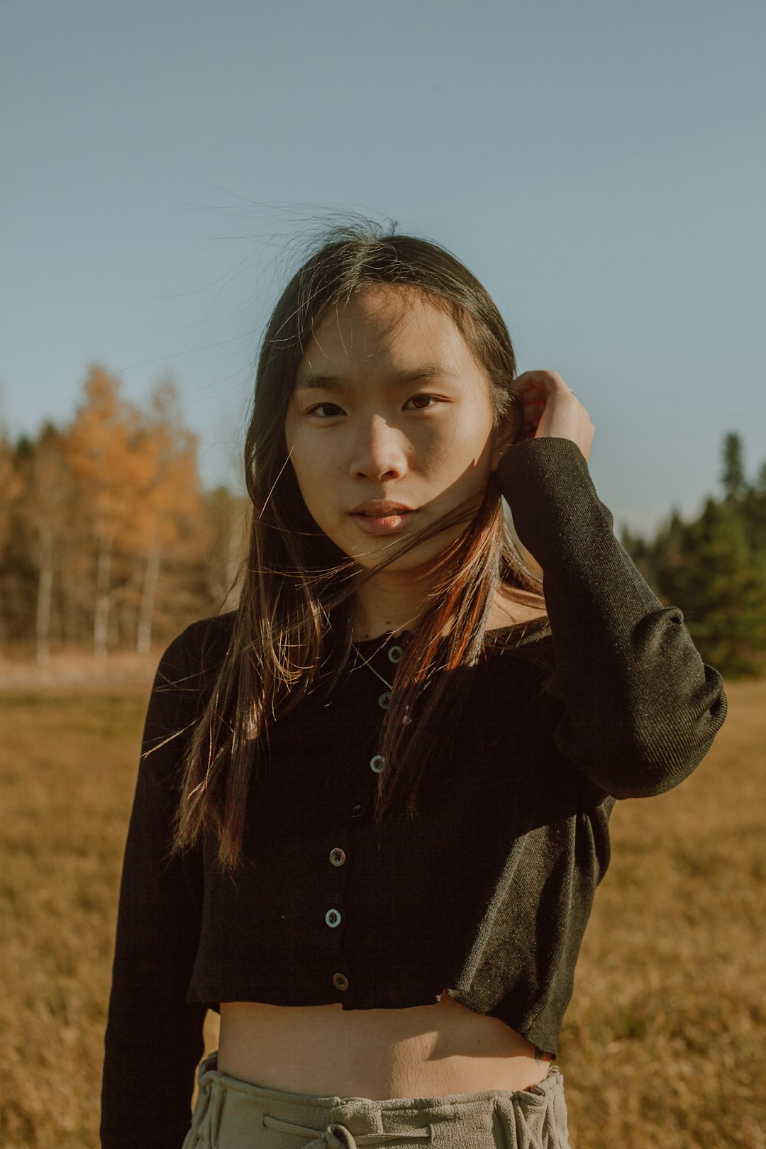 girl in black jacket standing on brown grass field during daytime