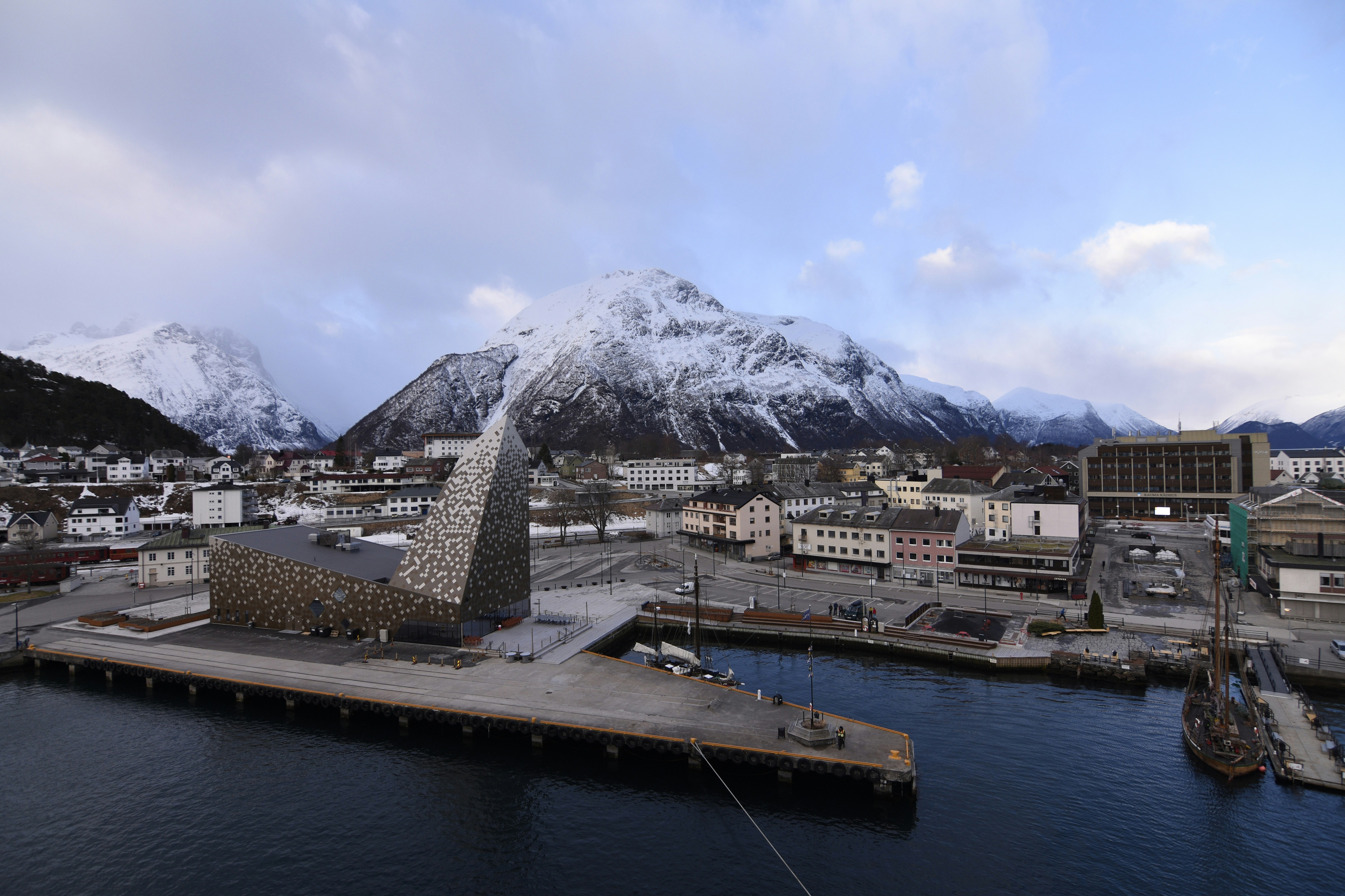 white and brown buildings near body of water and mountain under blue sky during daytime