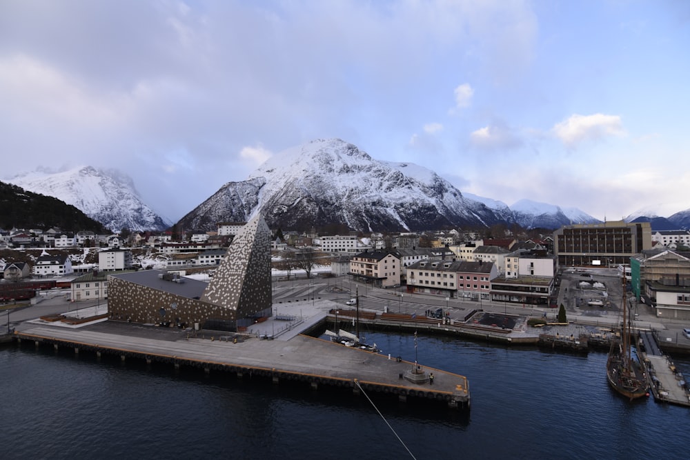 white and brown buildings near body of water and mountain under blue sky during daytime