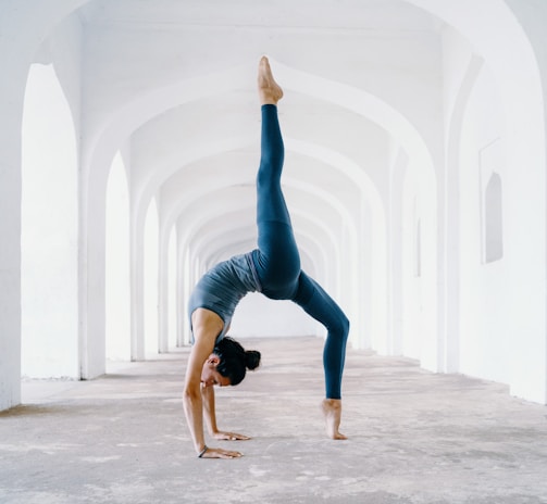 woman in blue leggings and black tank top doing yoga