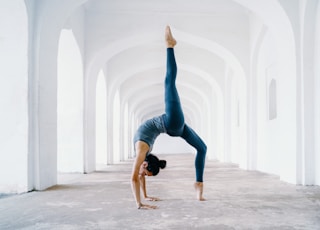 woman in blue leggings and black tank top doing yoga
