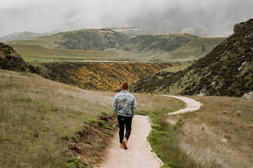 man in gray shirt walking on pathway