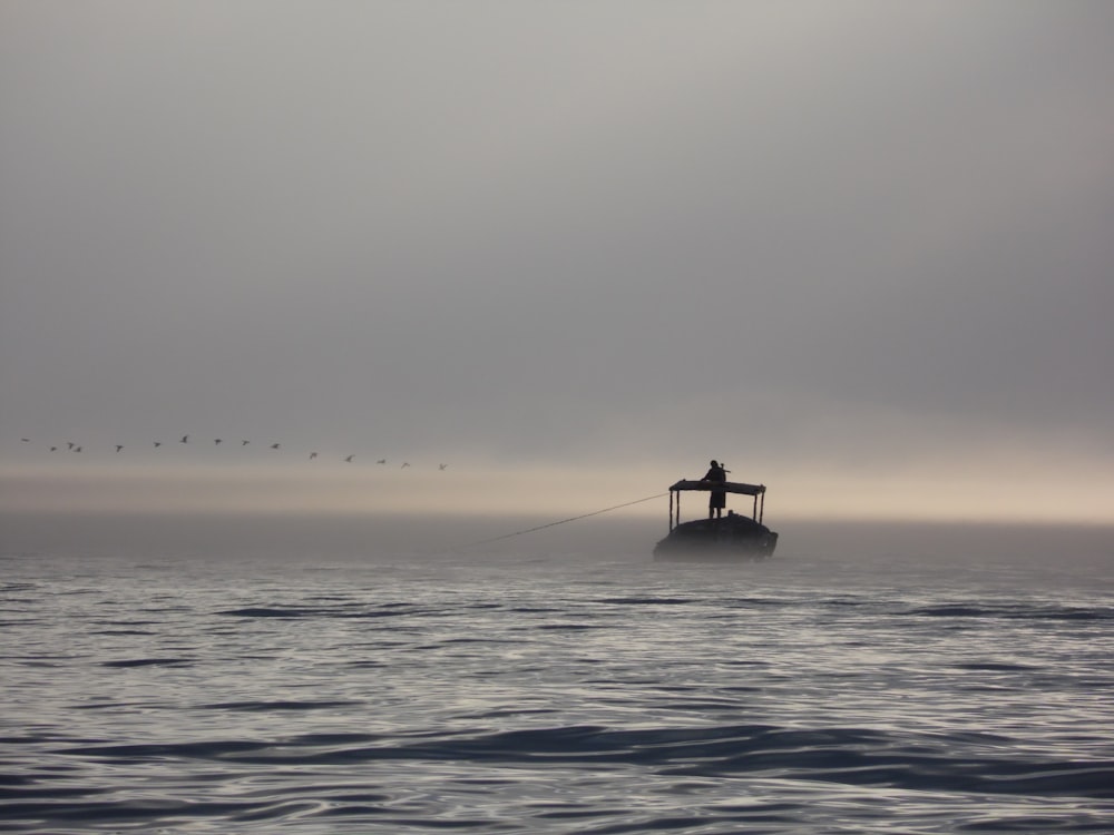 silhouette of person on body of water during daytime