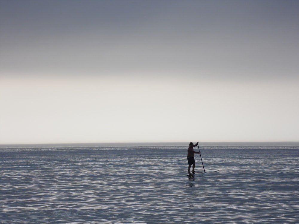 man in black jacket and pants standing on sea shore during daytime