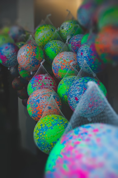 A vibrant assortment of colorful balls displayed on wooden shelves in a cozy shop setting.