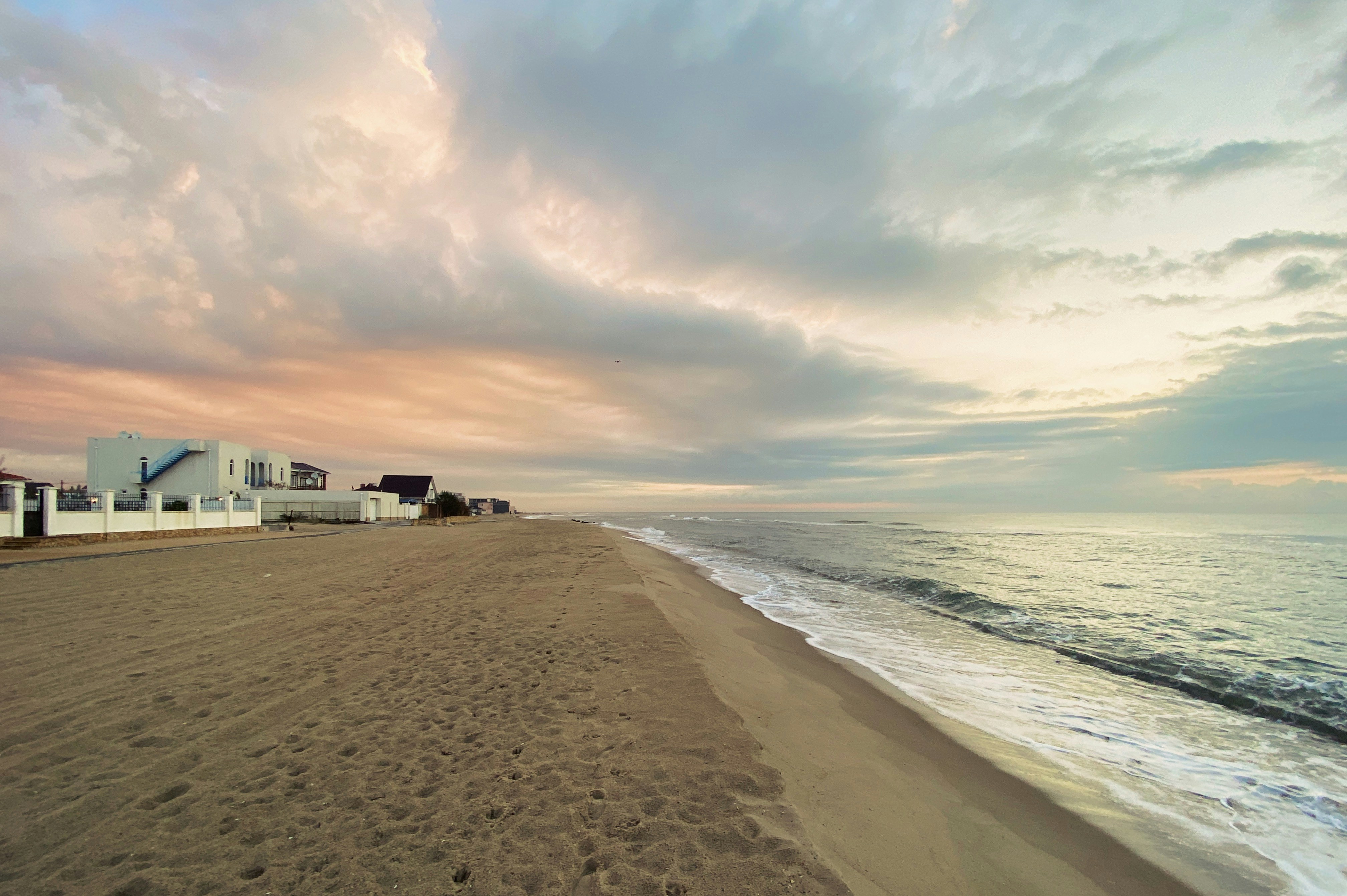 white and brown house near sea under white clouds during daytime, 
