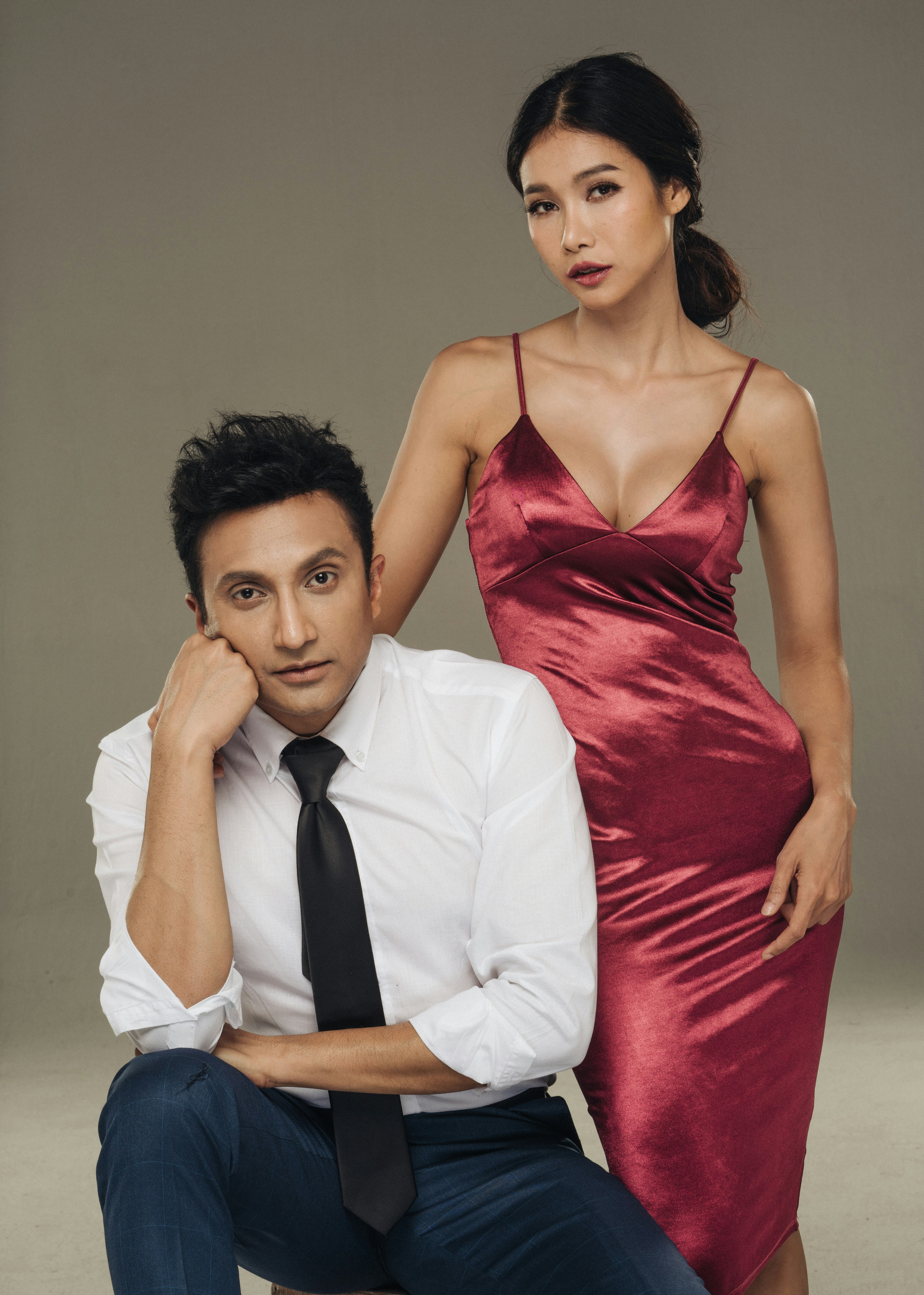 man in white dress shirt beside woman in red spaghetti strap dress