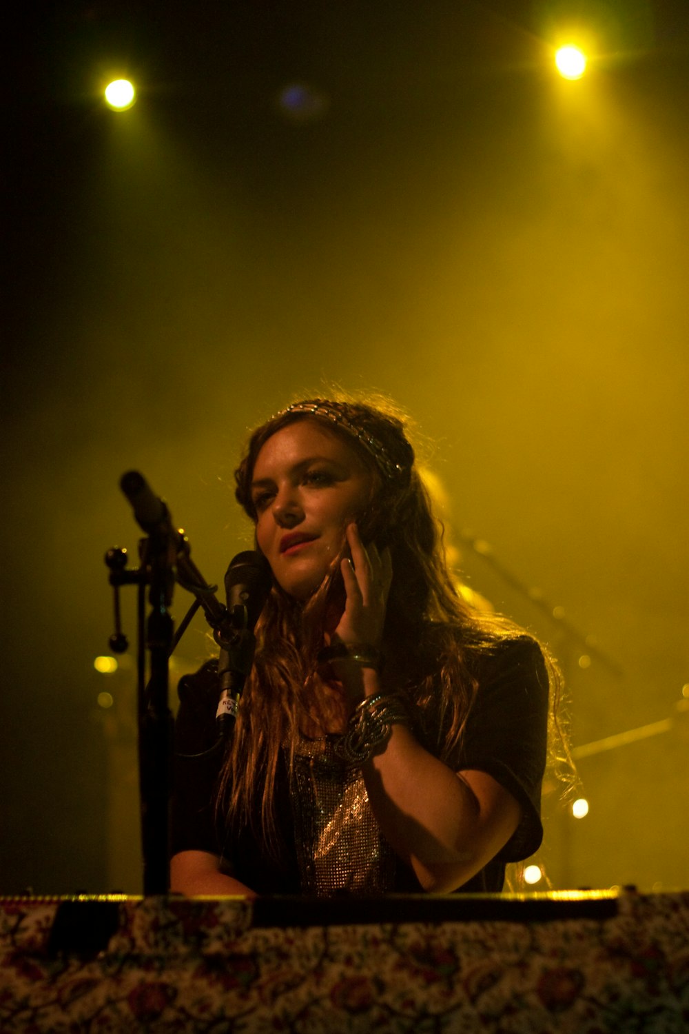 woman in black sleeveless top singing on stage