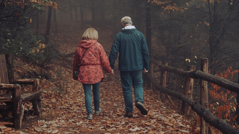 man in blue jacket and blue denim jeans standing beside woman in red jacket