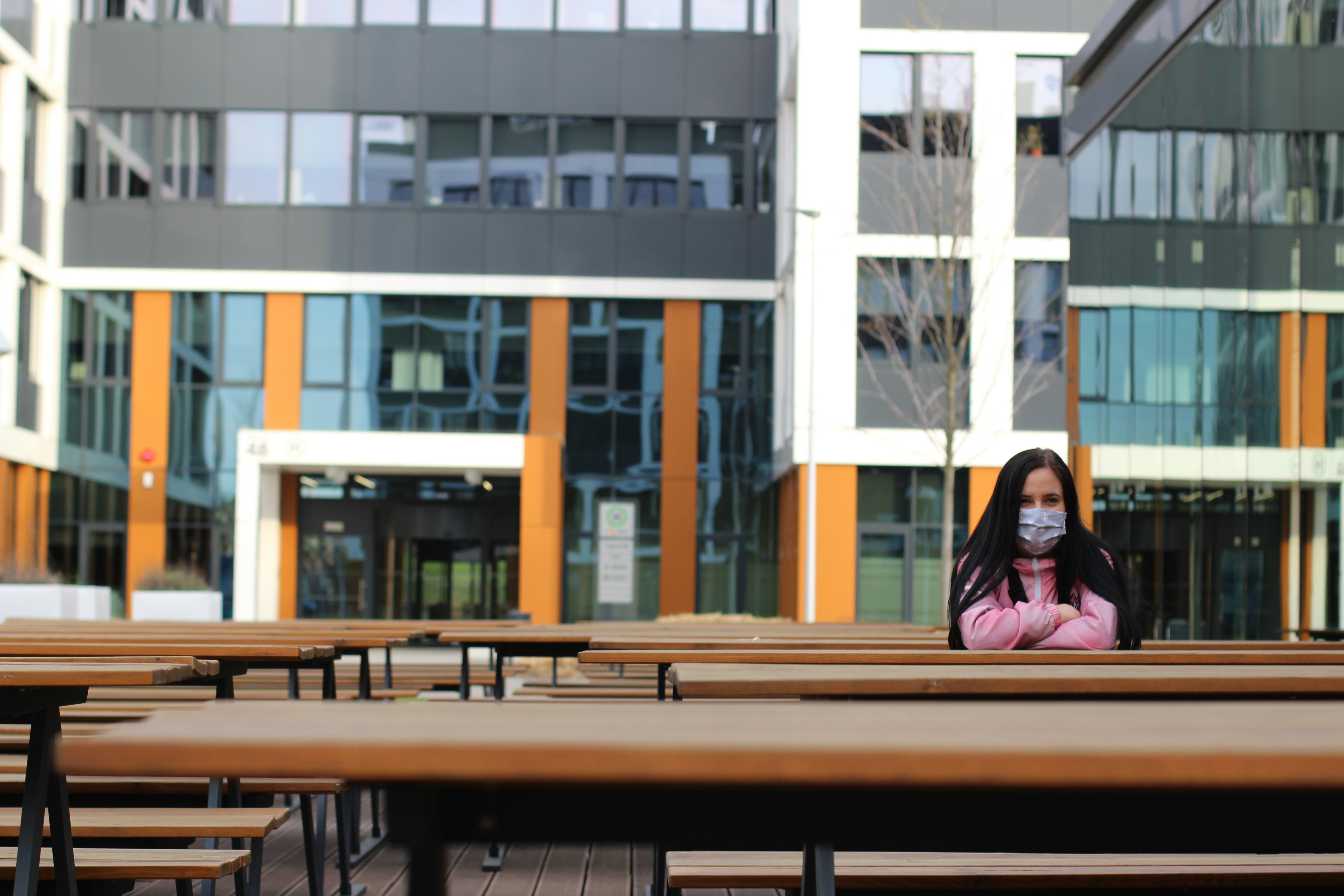 woman in black long sleeve shirt sitting on brown wooden bench