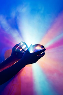 A calming scene of hands gently holding a vibrant healing crystal with soft light.