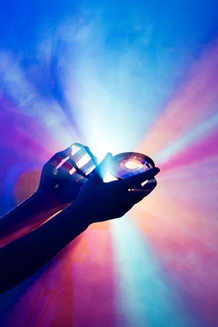 Hands gently holding a glowing violet crystal symbolizing spiritual awakening.