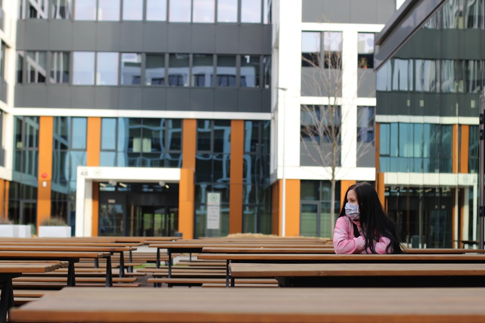 woman in black hijab sitting on brown wooden bench