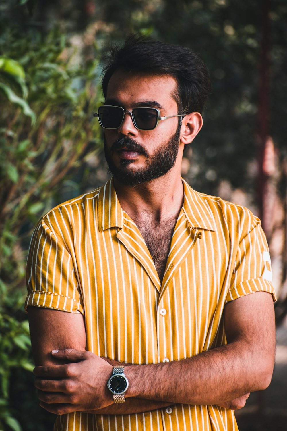 man in yellow and white striped button up shirt wearing black sunglasses