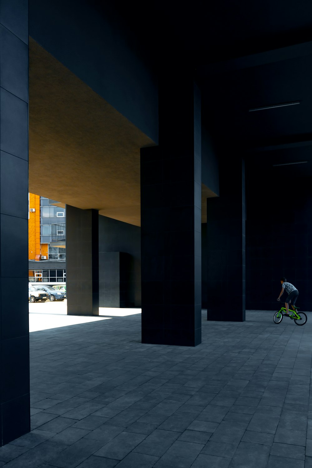 Bicicleta blanca y negra estacionada junto a un edificio de concreto marrón durante la noche
