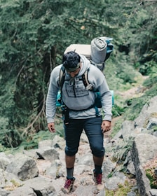 man in black and gray jacket and black helmet standing on rocky mountain during daytime