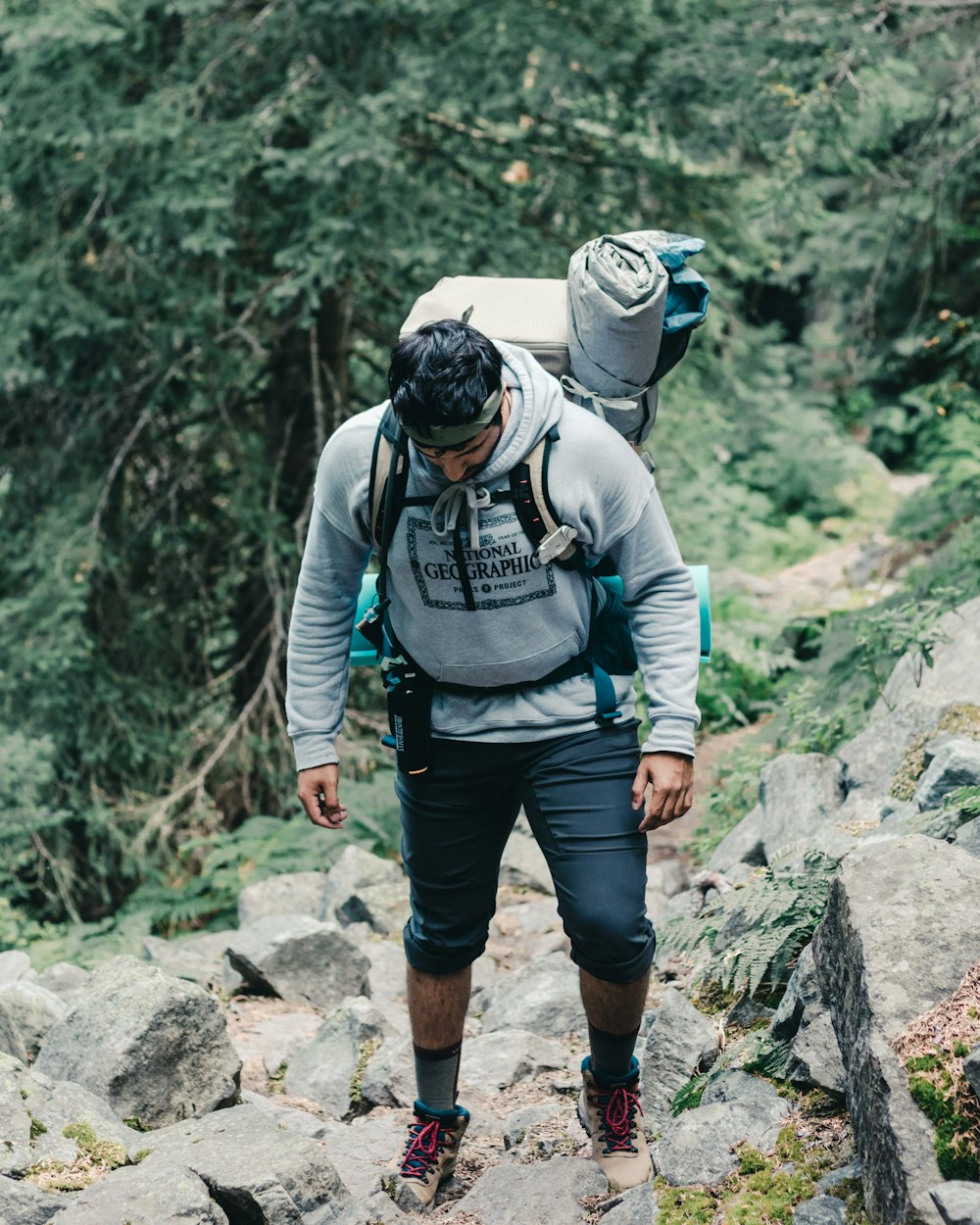 man in black and gray jacket and black helmet standing on rocky mountain during daytime
