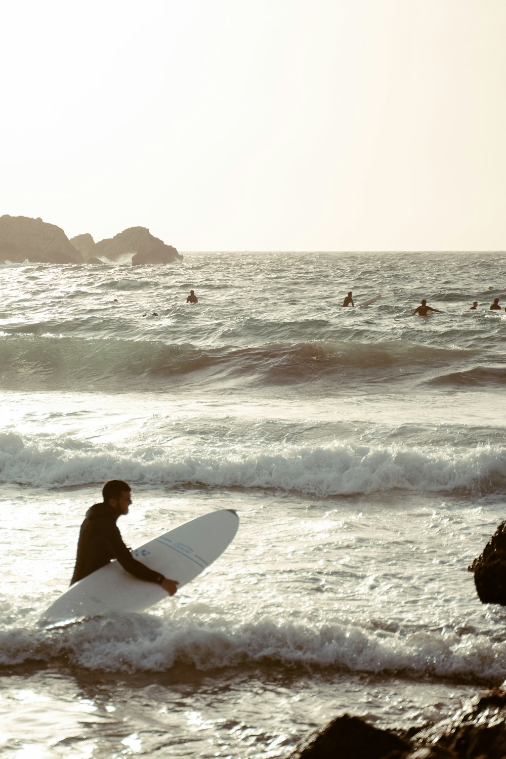 man in white surfboard surfing on sea waves during daytime