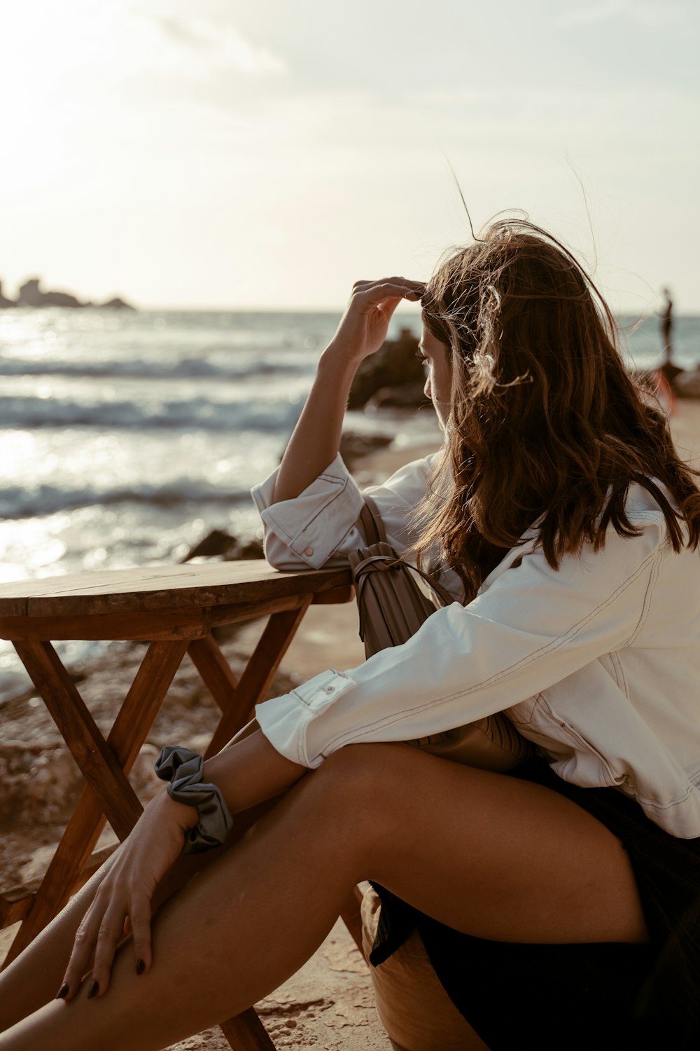 woman in white long sleeve shirt sitting on brown wooden chair