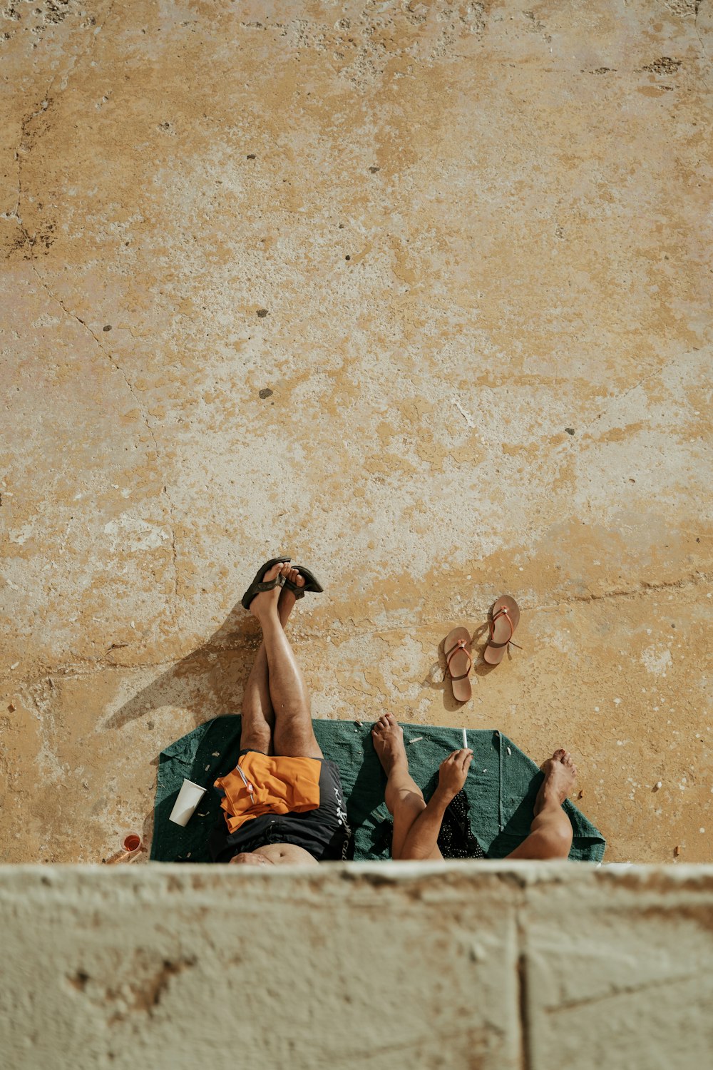 person in orange shorts lying on green bed