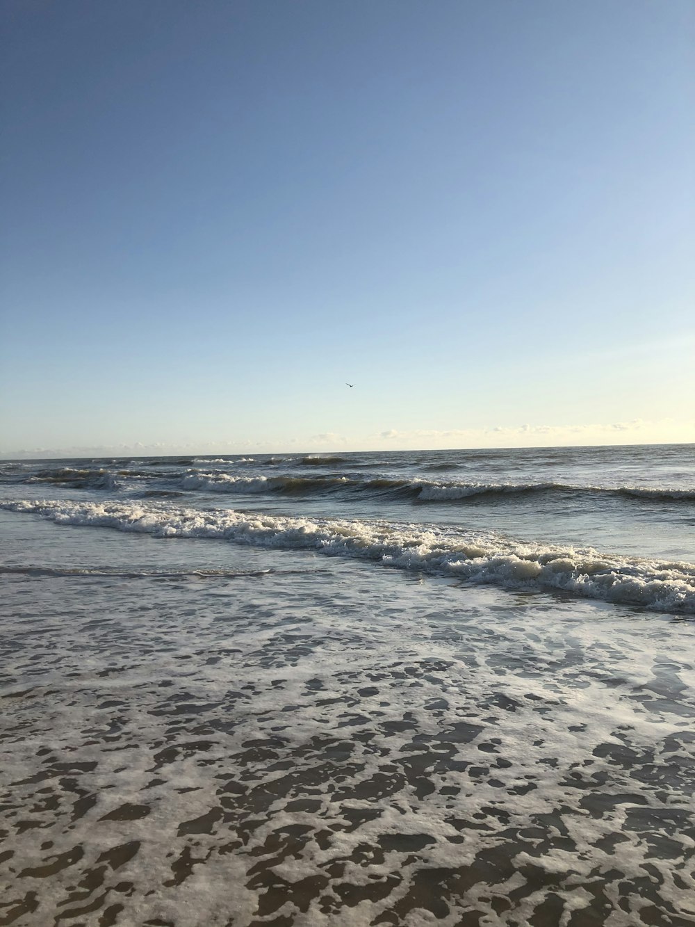 sea waves crashing on shore during daytime