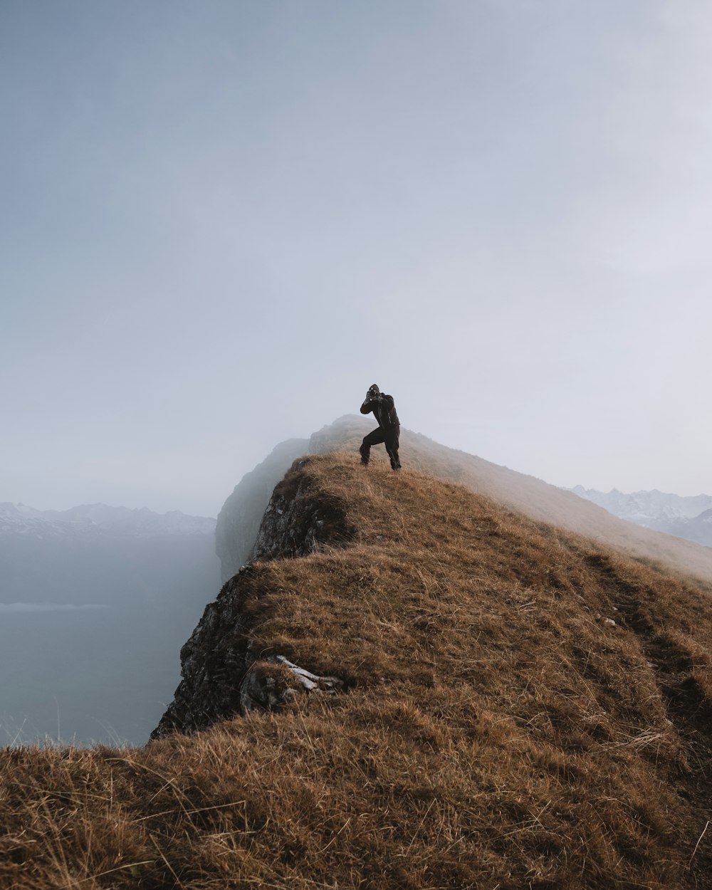 person standing on brown rock mountain during daytime