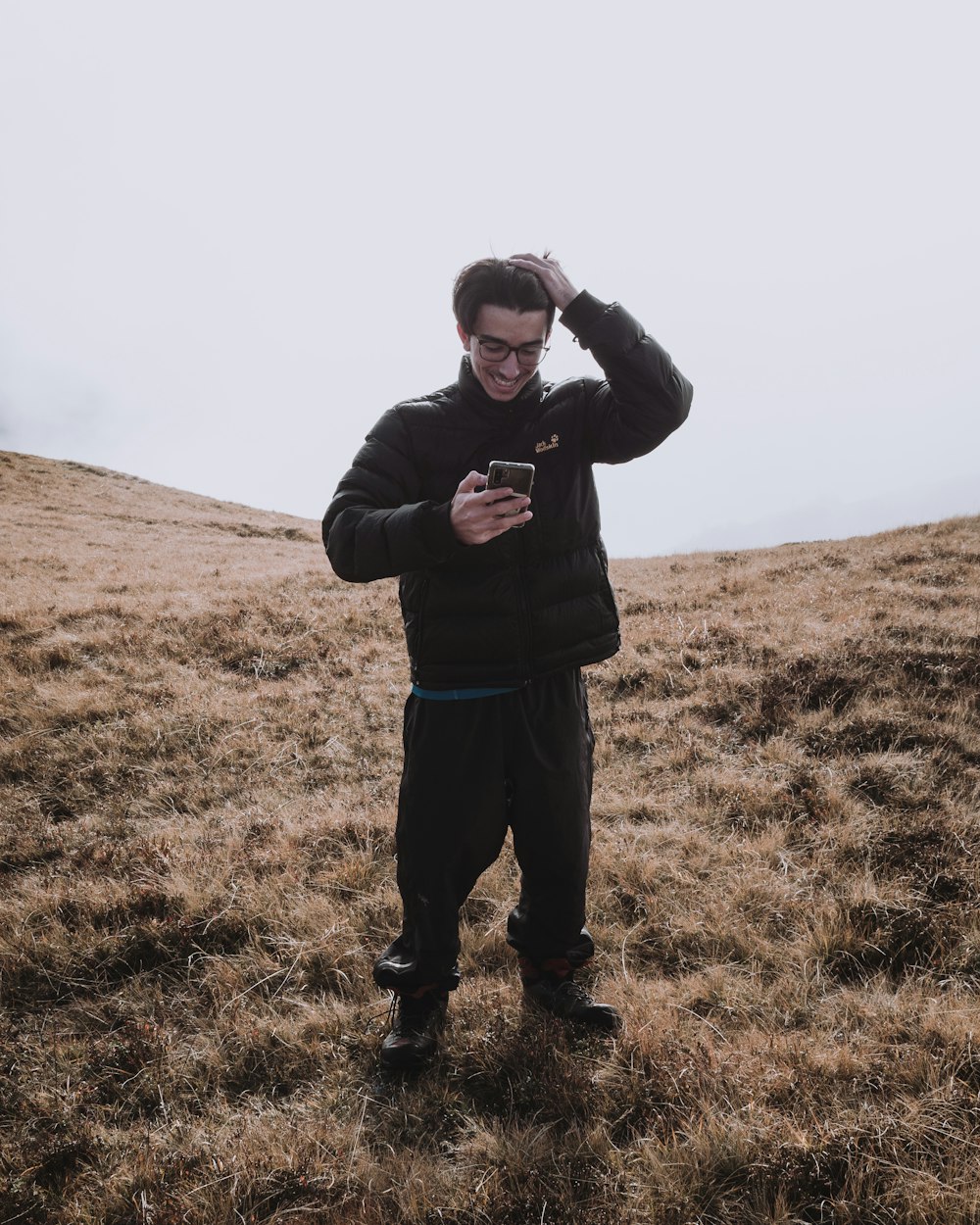 man in black jacket standing on green grass field during daytime