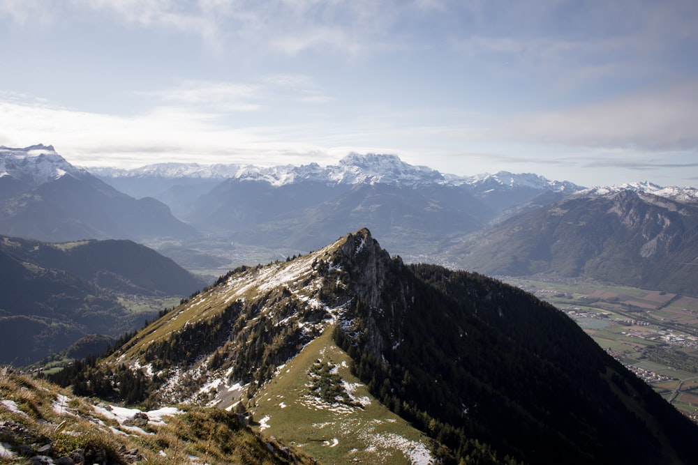 Grüne und weiße Berge unter weißen Wolken tagsüber