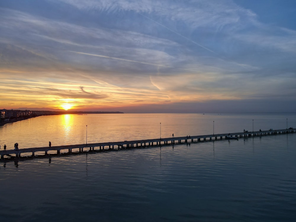 dock on body of water during sunset