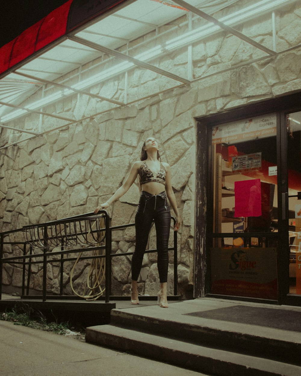 woman in white long sleeve shirt and black pants standing on black metal railings