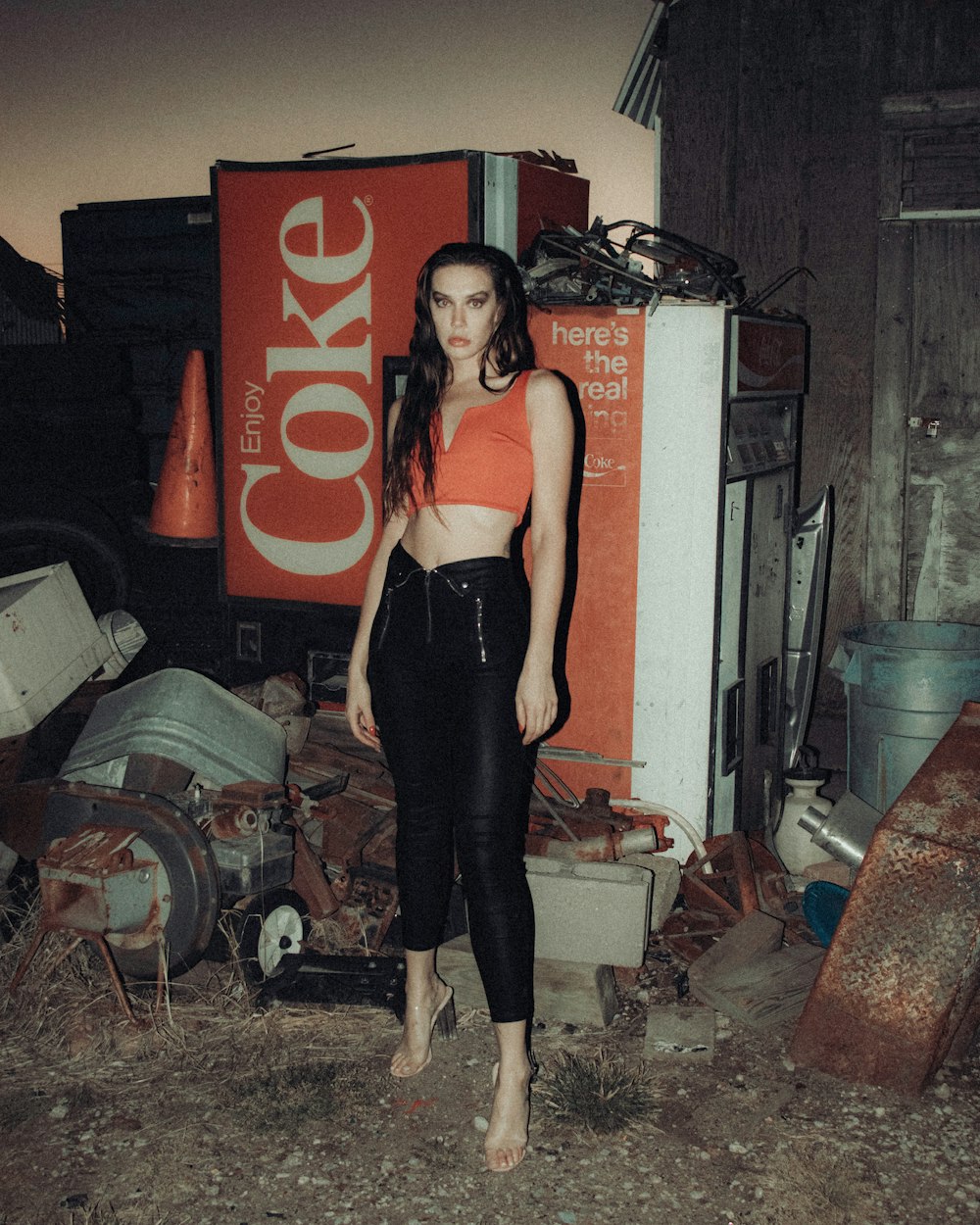 Frau in schwarzem Tanktop und schwarzer Leggings neben Coca-Cola-Box