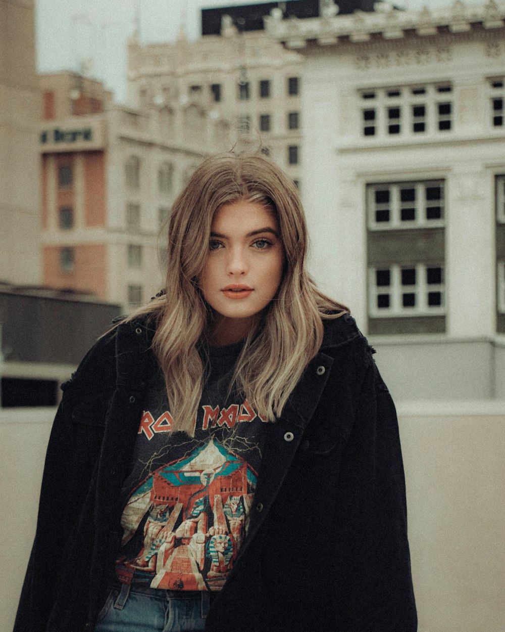 woman in black coat standing near building during daytime