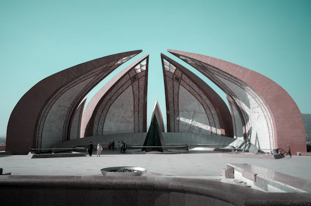 people sitting on bench in front of brown concrete building during daytime