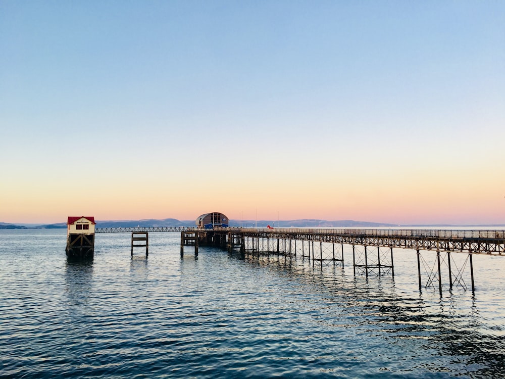 brown wooden dock on sea during sunset