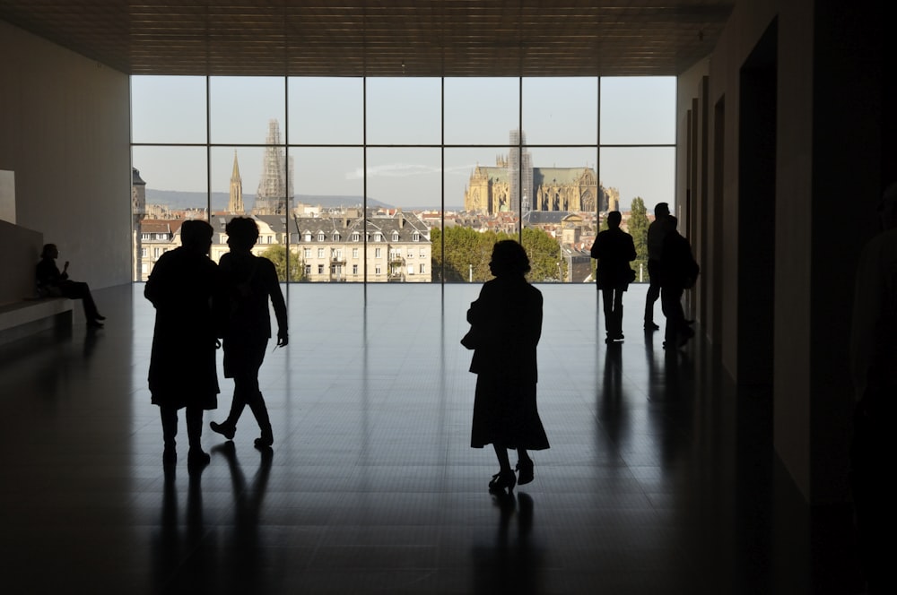 silhouette of people walking on sidewalk during daytime