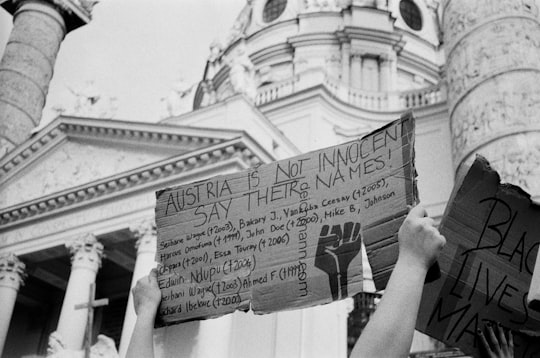 grayscale photo of person holding white printer paper in Karlskirche Austria