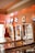 A room with several vintage pinball machines arranged in a row. Neon signs for various brands including Pepsi Cola are affixed to the wall above the machines. The ambiance is warm and nostalgic with a mix of bright and soft lighting.