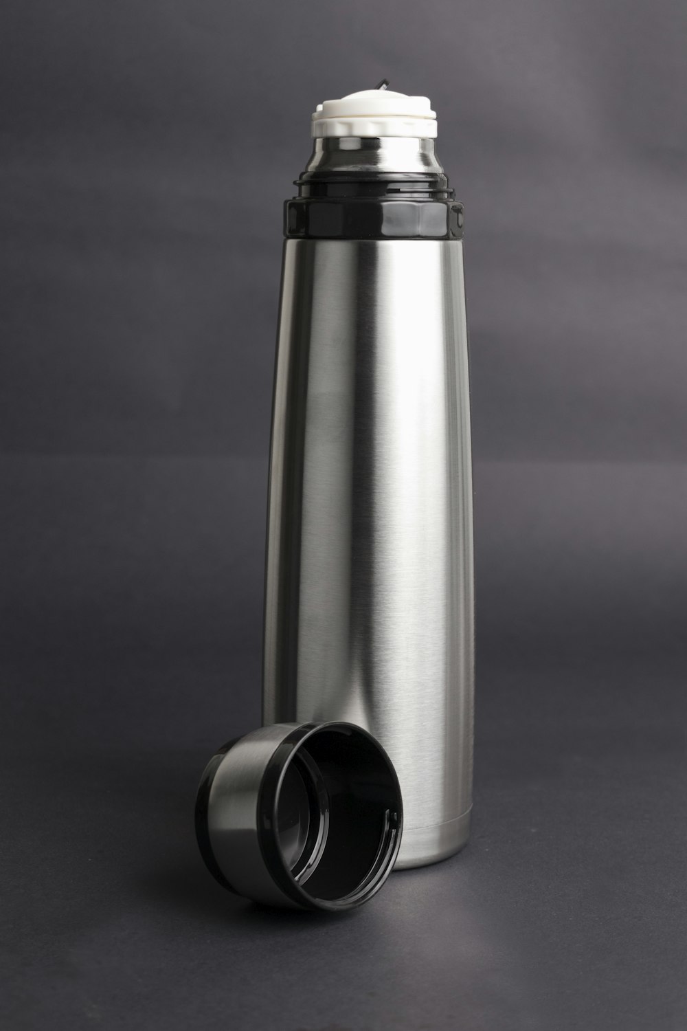 stainless steel vacuum flask on blue surface