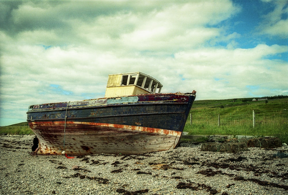 brown and white boat on brown sand under blue sky during daytime