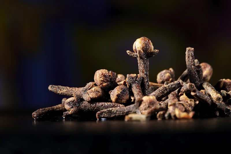 Whole dried cloves on a dark surface
