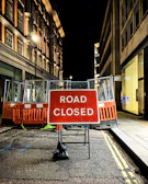 Wide shot of road closure barriers and clear signage during a night operation.