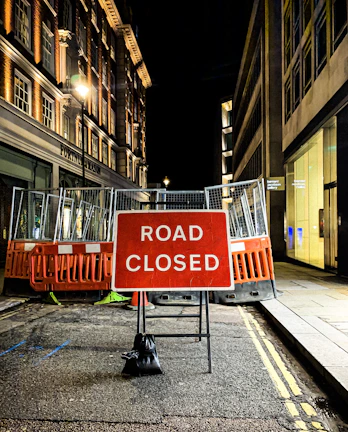 Wide shot of road closure barriers and clear signage during a night operation.